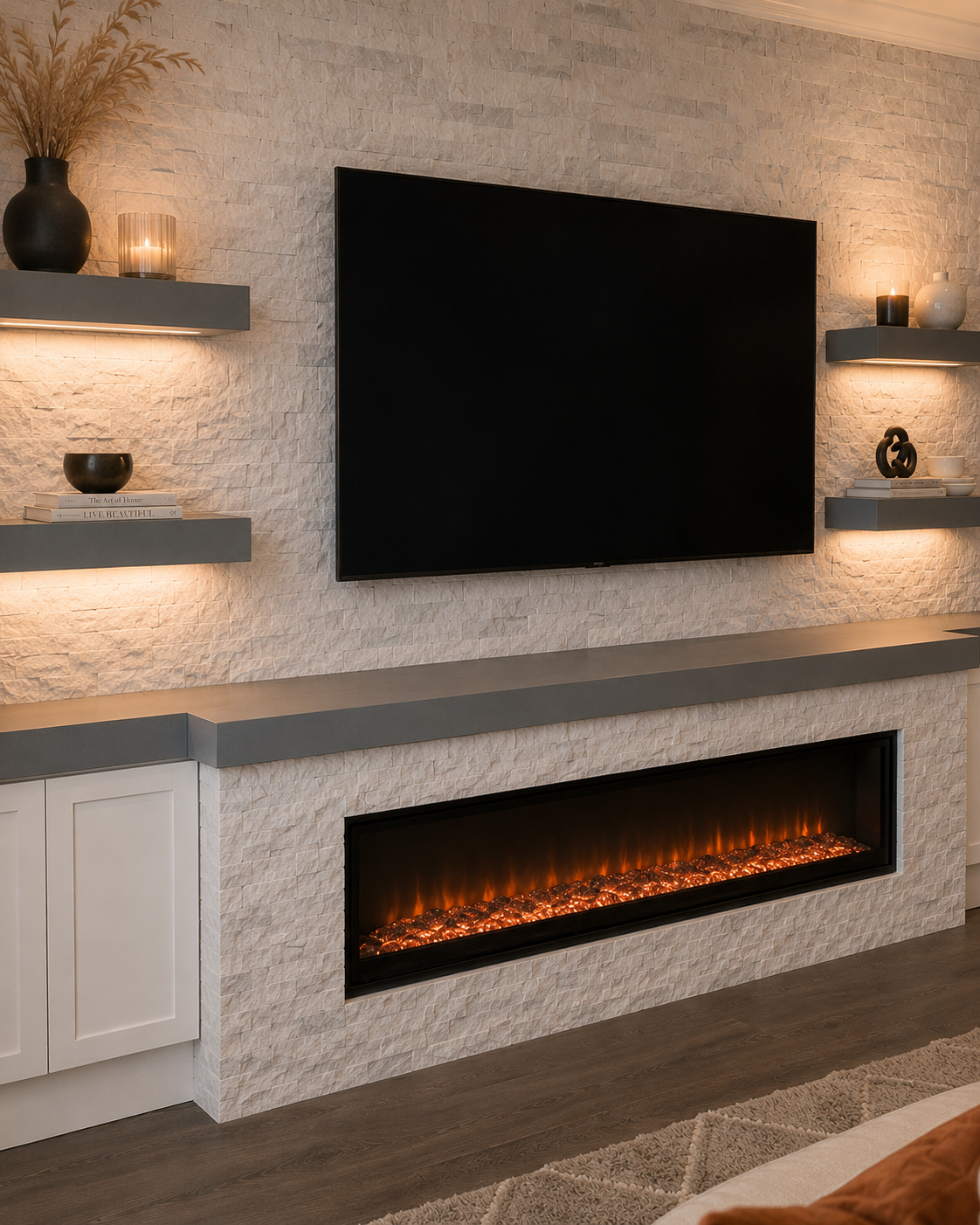 Detail view of the Altamonte Springs Custom Fireplace TV Wall with light natural stone, thick painted floating shelves, warm linear lighting, mounted TV, long countertop, and electric fireplace.