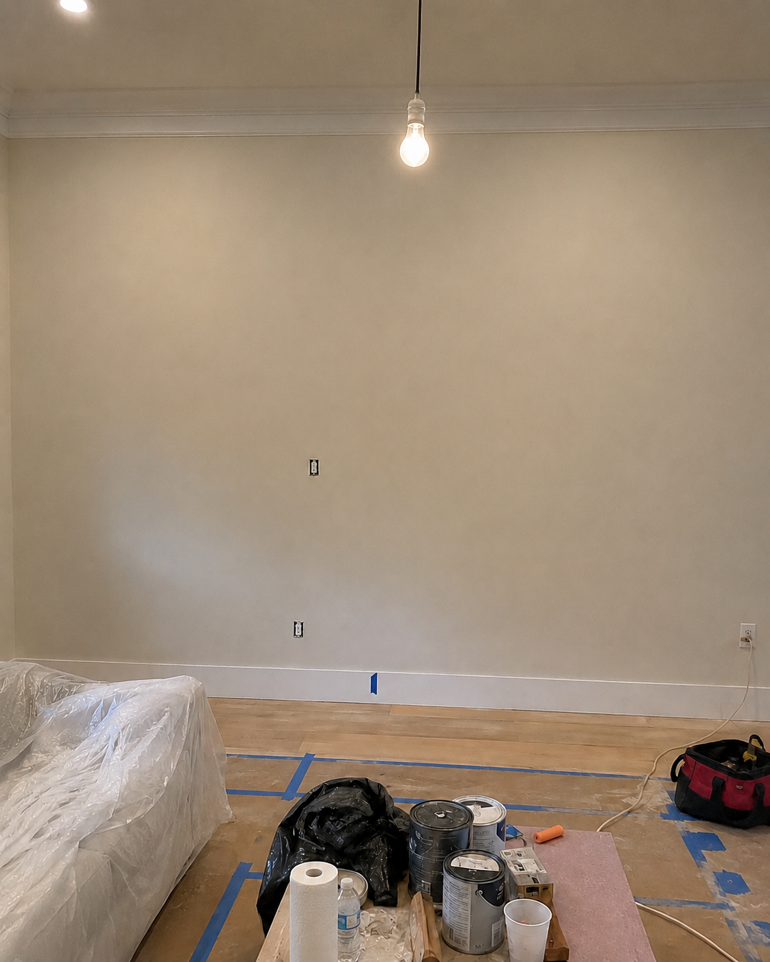 Before view of a plain warm-ivory wall in a second-floor Longwood living room before construction of the Custom Fireplace TV Wall.