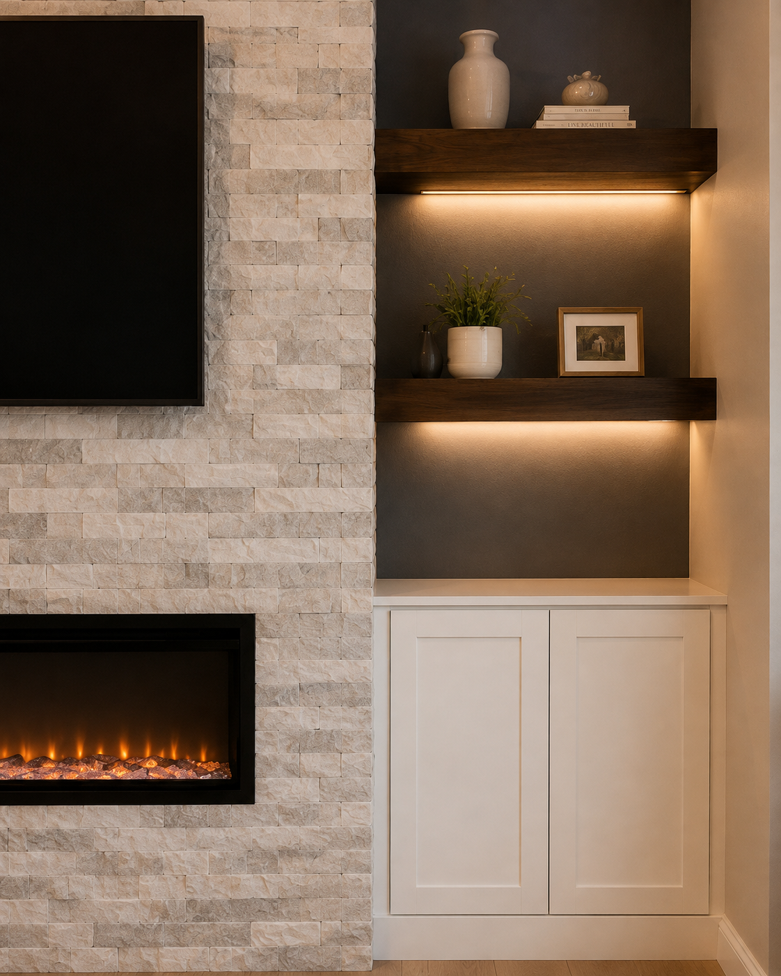 Detail of the Mount Dora fireplace wall showing light gray-and-white natural stacked-stone cladding beside two thick dark floating shelves with warm linear lighting and a custom white two-door base cabinet.