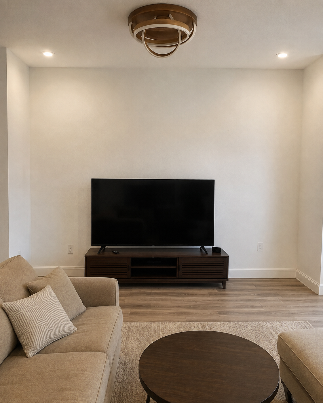 Before view of the Winter Garden living room with a plain wall and television on a low media console before the Custom Fireplace TV Wall was built.