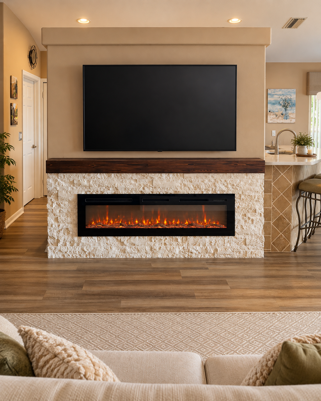 Front view of a Fort Myers fireplace TV wall with pale ivory stone, a dark stained wood mantel and a linear electric fireplace beneath the television.